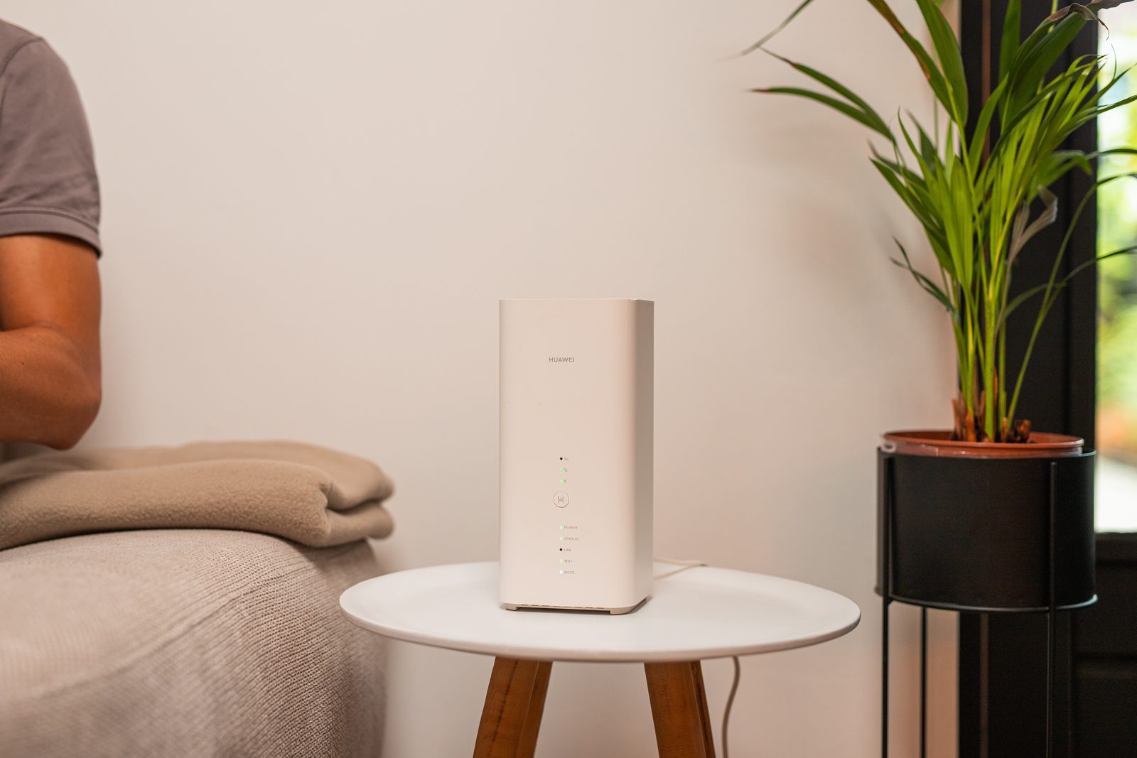 Wit 4G/5G-modem op een bijzettafel naast de bank in een woonkamer