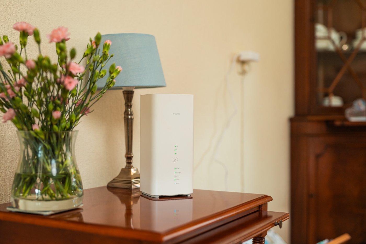 Het 5G-modem op een kast naast een vaas met bloemen